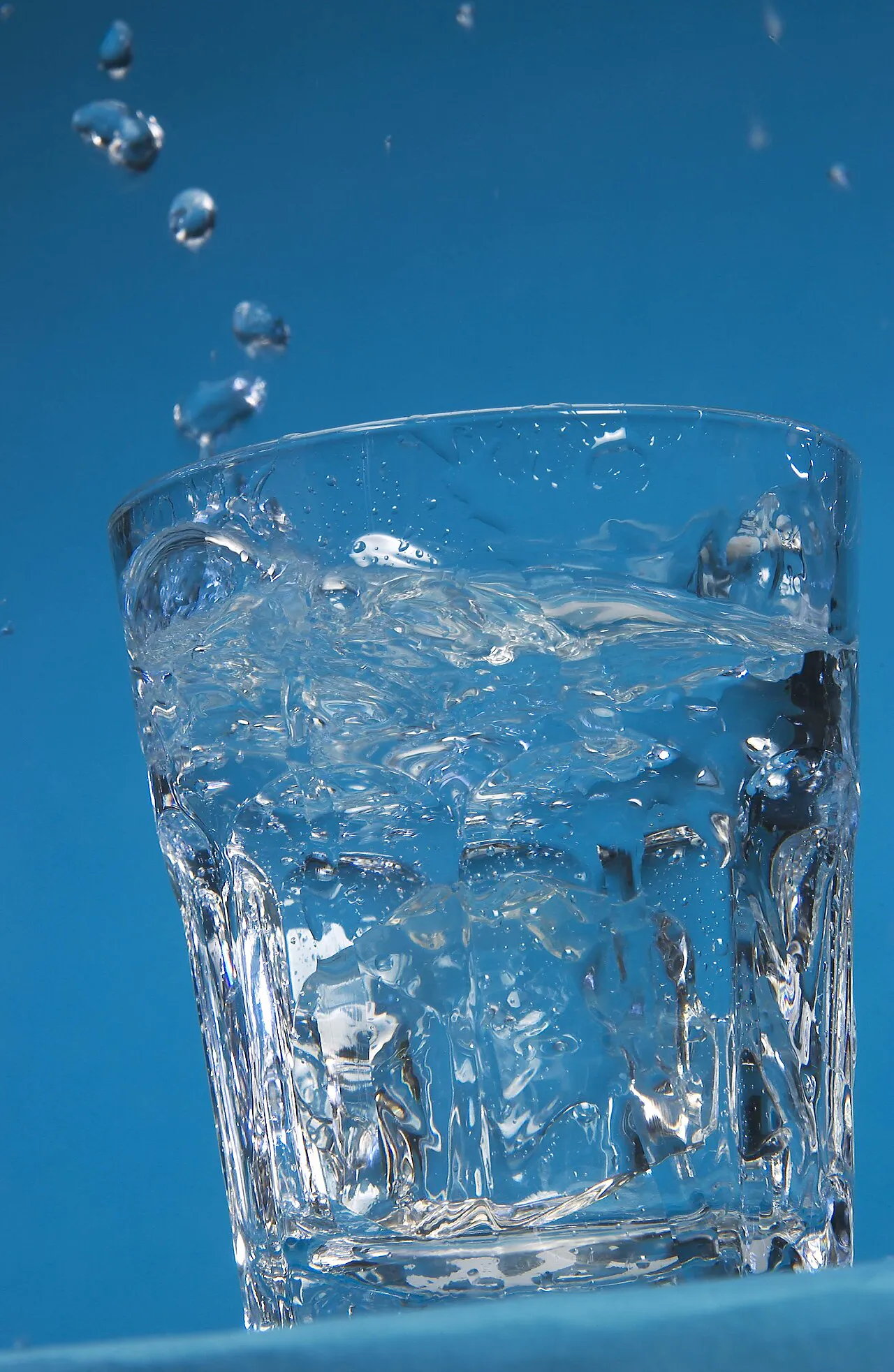 Clear water splashing out of a glass